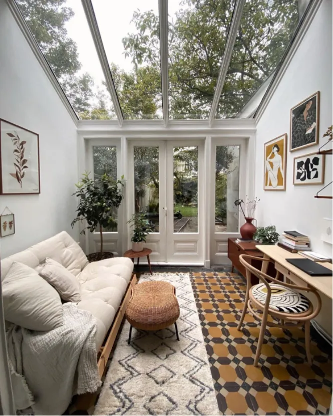 A cozy modern glass sunroom blending indoors and outdoors