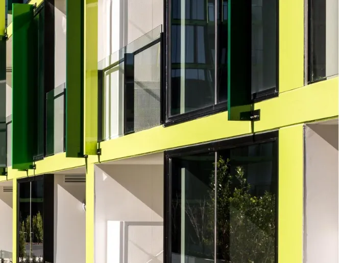 High-rise apartment façade featuring large insulated glass units and modern green exterior panels